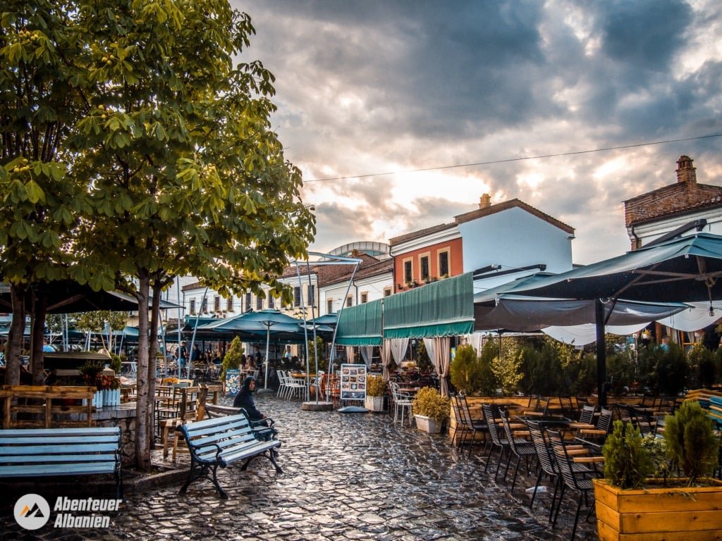 View of the new bazaar in Korça with lively coffee shops, terraces with chairs, combining modern and traditional elements.