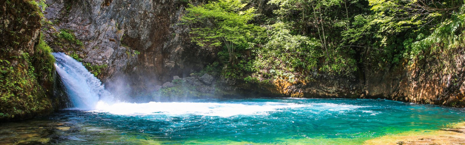 Crystal clear waters and waterfall of Syri i Kaltër Blue Eye in Theth, Albanian Alps