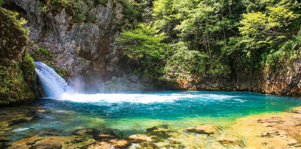 Crystal clear waters and waterfall of Syri i Kaltër Blue Eye in Theth, Albanian Alps