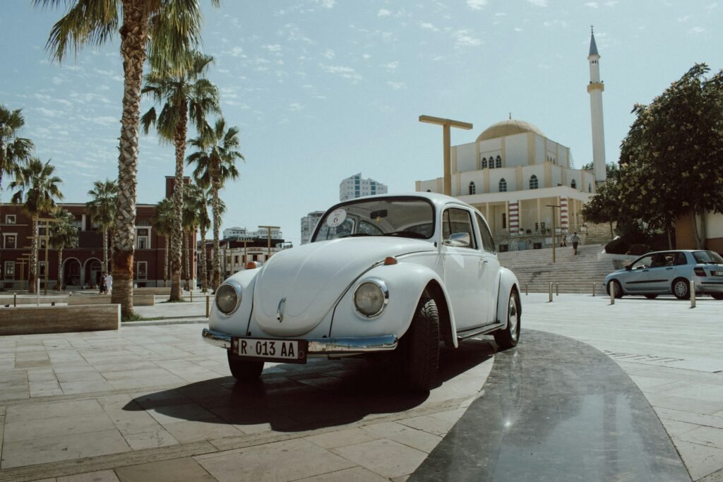 Vintage Volkswagen Beetle in Durres City Hall Square with Mosque in Background - Beige Retro Car in Albania