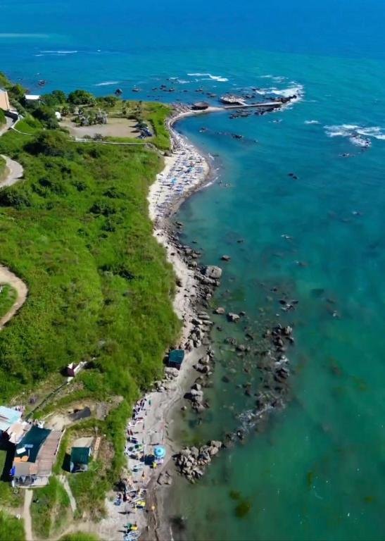 Aerial View of Currila-Kallmi: Green Hills, Stony Beach, and Adriatic Sea