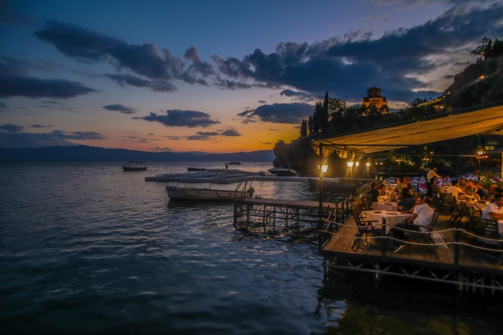 Night view of Ohrid Town reflecting in Lake Ohrid, illuminated by the city lights, creating a magical scene.